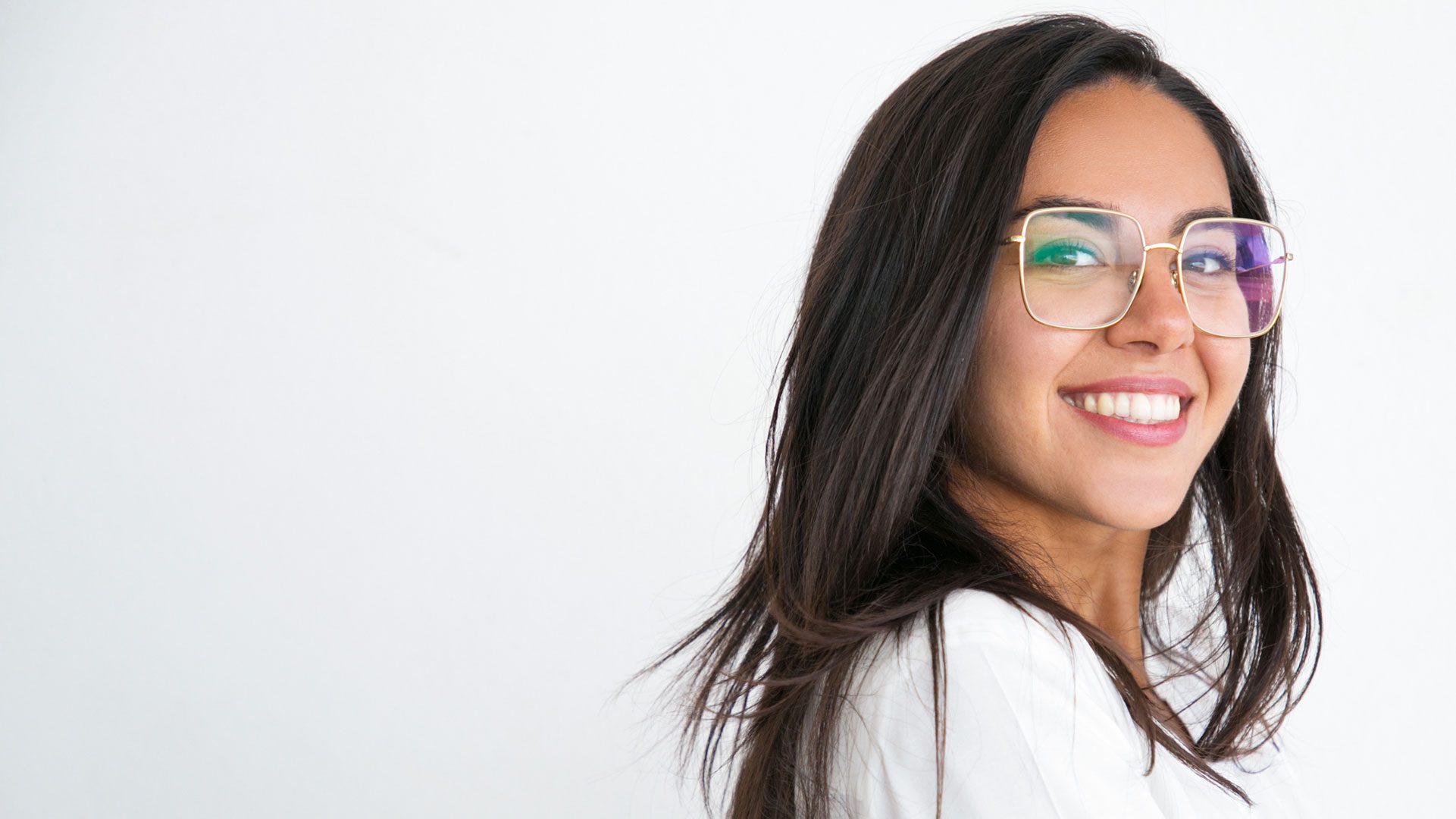 young woman in white shirt wearing gold glasses smiling